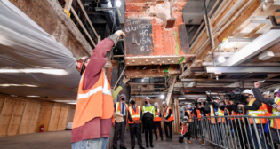 MTA is advancing Penn Station reconstruction with the removal of seven low-hanging beams, dubbed “Head Knockers.” The beams, weighing in at 10 tons apiece, are part of the original Penn Station structure and have limited passageway heights to 6 feet, 8 inches.