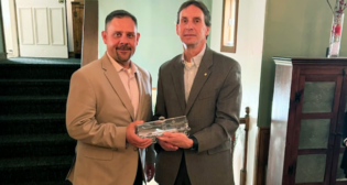Diversified CPC International Director-Supply Chain and Logistics Chad Rainey (left) presents an Excellence in Partnership Award to New York, Susquehanna and Western Railway Corp. President Nathan Fenno.