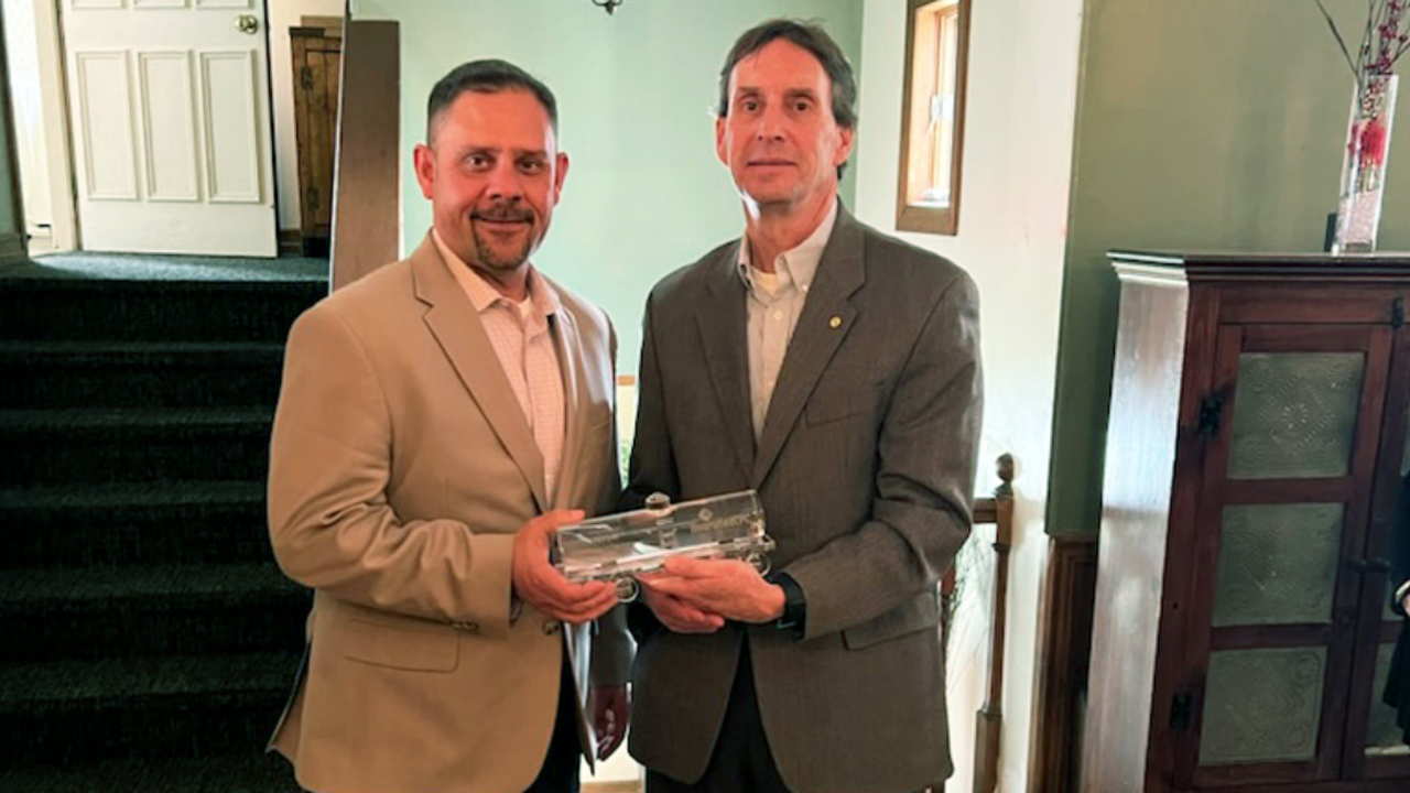 Diversified CPC International Director-Supply Chain and Logistics Chad Rainey (left) presents an Excellence in Partnership Award to New York, Susquehanna and Western Railway Corp. President Nathan Fenno.