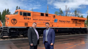 “CP celebrated the opening of a new border station in Jackman, Maine today [May 17] with @CBP & @HapagLloydAG. This new live lift operation will help create a seamless service between @PortSaintJohn & terminals in Canada & the U.S.,” the Class I railroad reported on Twitter. Pictured: Hapag-Lloyd’s Jason Tock (left) and CP’s Todd Ferland. (Photograph Courtesy of CP via Twitter)