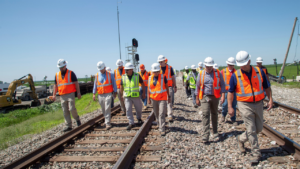 NTSB Chair Homendy and NTSB investigators, along with investigation party members, walk the accident scene of the June 27 grade crossing collision and derailment between an Amtrak passenger train and dump truck near Mendon, Mo. (Photograph and Caption Courtesy of NTSB, via Twitter, June 29)