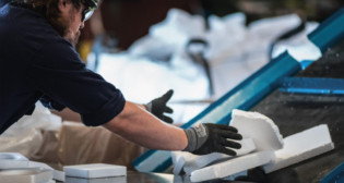 A Cyclyx employee feeds post-use polystyrene onto a conveyer belt to shred and prepare it for the chemical recycling process. (Photograph and Caption Courtesy of UP)