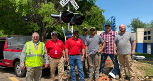 Part of the R.J. Corman team that helped install the new highway/rail grade crossing signals for Safety City, a safety program for second-graders run by the Lexington, Ky., Police Department. From left to right: R.J. Corman Signaling AVP of Engineering Signaling Rocky Metz; R.J. Corman Signaling General Manager Rich Barsalona; R.J. Corman Signaling Senior Systems Engineer Matthew Hamlin; R.J. Corman Railroad Services Signal Specialist Jared Lundy; R.J. Corman Railroad Services Signal Specialist Travis Lundy; R.J. Corman Railroad Services AVP of Signal Construction Larry Yeager; and R.J. Corman Railroad Services Signal Construction Ryan Hale. (Caption and Photograph Courtesy of R.J. Corman)