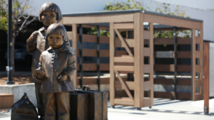 The memorial at the San Bruno BART Station plaza based on a Dorothea Lange photograph of Mochida sisters departing for incarceration at Tanforan. (Photograph and Caption Courtesy of BART)