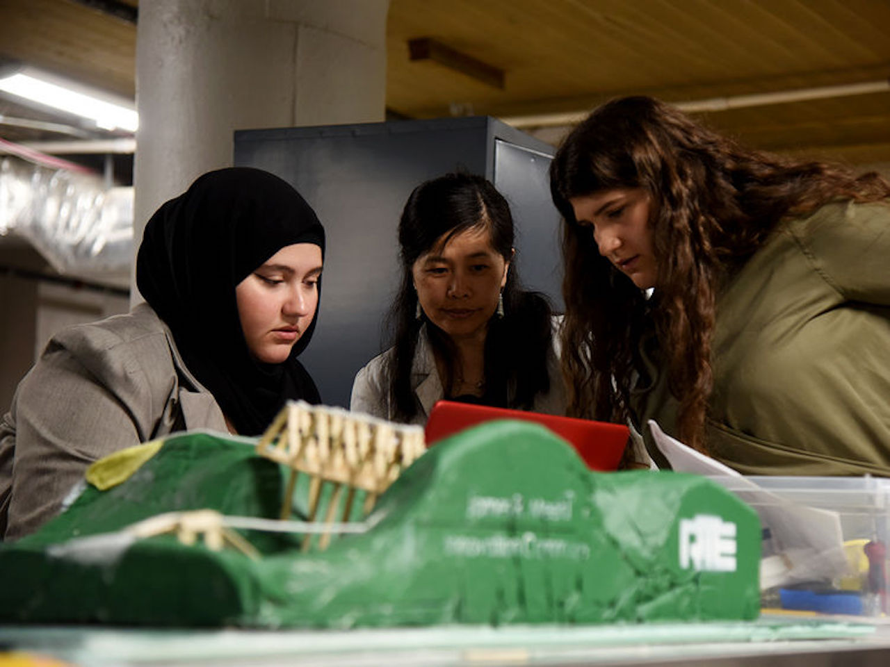 Penn State Altoona students Hagar Abdelaal (left) and Alyonna Vitulli (right) work with Shihui Shen, Professor of Rail Transportation Engineering, during the fourth annual Women in Engineering Design competition. (Credit: Jacob Narup of Penn State)