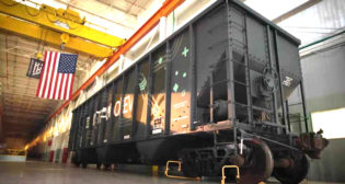 According to Intramotev, its ReVolt cars remain in the train consist “to capture energy via regenerative braking and reduce locomotives’ diesel consumption,” while its TugVolt cars (pictured)—supplied as a “proprietary kit that can retrofit/upfit existing railcars to become battery-electric”—can decouple from the consist to independently provide first- and last-mile service.
