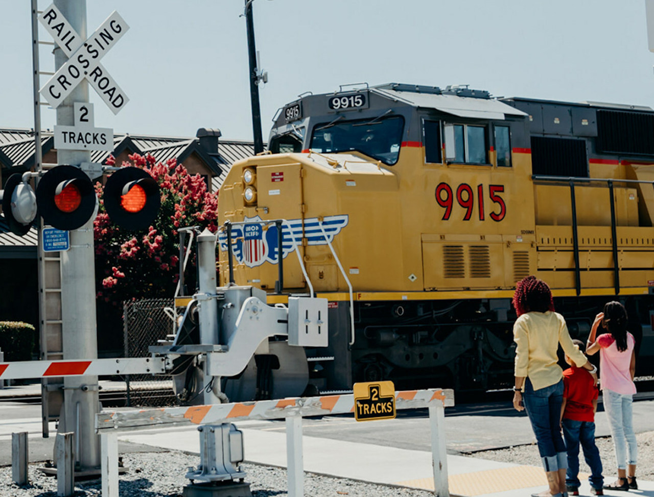 Only cross train tracks at a designated crossing. Designated crossings are marked by a sign, lights, or a gate. (Safe Kids Worldwide photo)