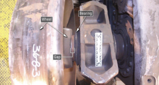 The NTSB observed the inspection and disassembly of wheelset #4 from railcar 7200, which caused the 2021 Washington Metropolitan Area Transit Authority derailment in Virginia. “In accordance with wheelset design, each wheel should have been flush against its bearing when mounted,” NTSB wrote in its January 2023 derailment investigation report. “Before disassembly, the inspection identified gaps between both wheels and their respective bearings: about 0.63 inches for the right-side wheel and about 1.10 inches for the left-side wheel [see above] … The back-to-back measurement was about 55.375 inches, or about 2 inches wider than the maximum design specification.” (NTSB Image)